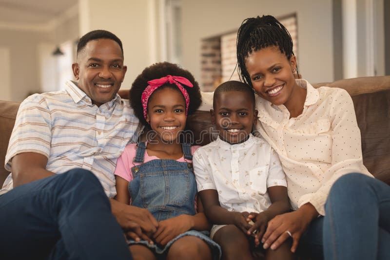 Happy African American family sitting on the sofa and looking at camera royalty free stock image Happy African American family sitting on the sofa and looking at camera royalty free stock image