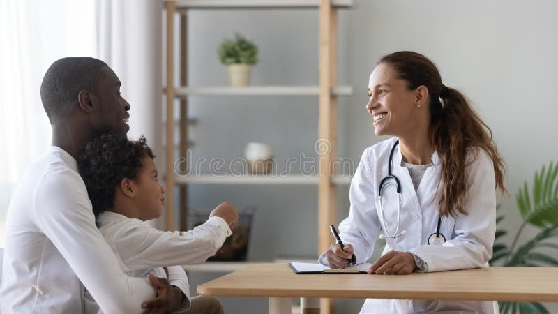 Happy african american man visiting friendly female pediatrician with son. royalty free stock image Happy african american man visiting friendly female pediatrician with son. royalty free stock image
