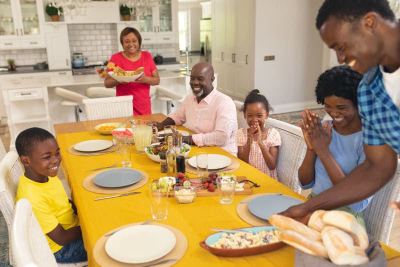 Happy african american multi-generational family having lunch at home on thanksgiving day