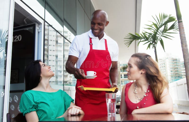 Happy african american waiter at work in a restaurant royalty free stock images