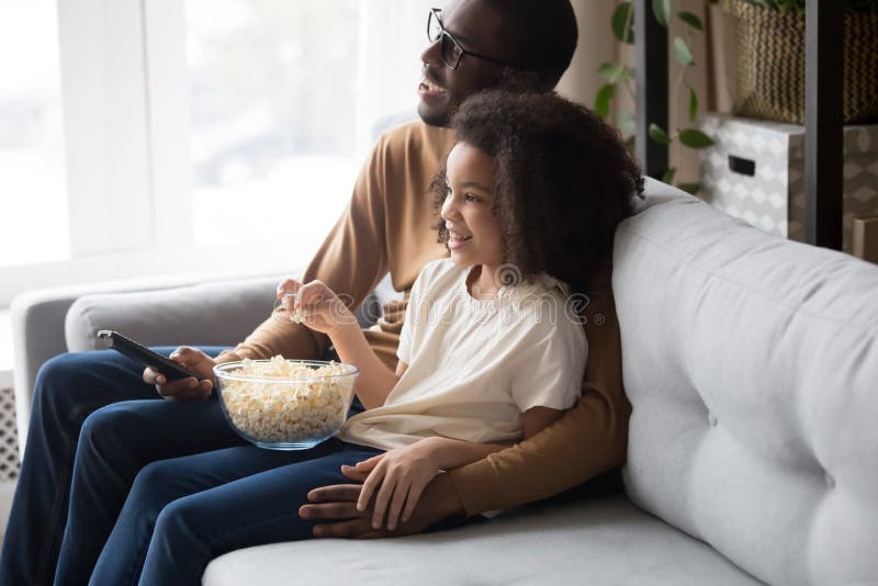 Happy african family dad with child daughter watching tv together royalty free stock image Happy african family dad with child daughter watching tv together royalty free stock image