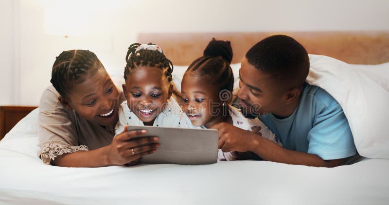 Happy African family tablet lub relaks w sypialni w domu streamowanie filmu lub oglądanie kreskówki z rodzicami. Ojciec matki obraz royalty free