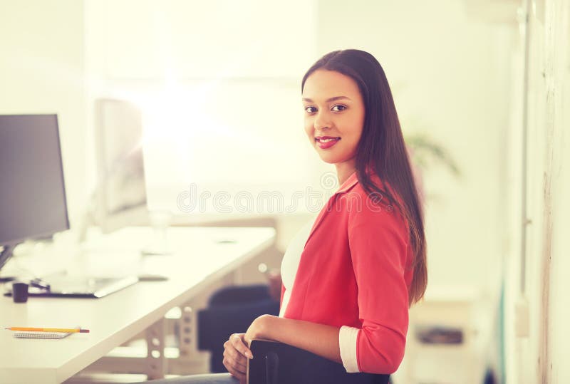 Happy african woman with computer at office