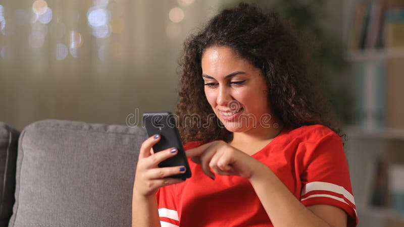 Happy arab girl using smart phone at home