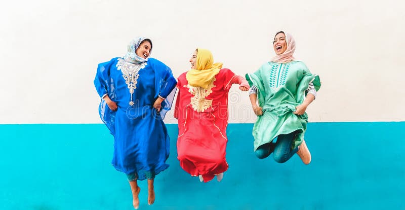 Happy arabische Freundinnen, die sich im Freien amüsieren - Junge islamische Mädchen springen und lachen - Freundschaft, Jugend, lizenzfreie stockfotos Happy arabische Freundinnen, die sich im Freien amüsieren - Junge islamische Mädchen springen und lachen - Freundschaft, Jugend, lizenzfreie stockfotos
