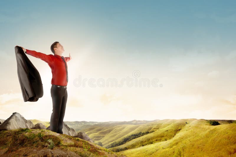 Happy asian businessman holding a suit standing on top of mountain celebrate his successful royalty free stock photos Happy asian businessman holding a suit standing on top of mountain celebrate his successful royalty free stock photos