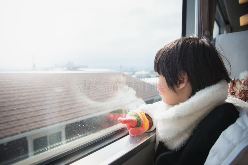 Happy asian child looking out train window outside. Happiness, look.