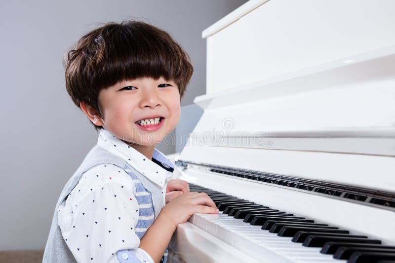 Happy Asian Chinese Little Boy Playing Piano At Home Stock ...