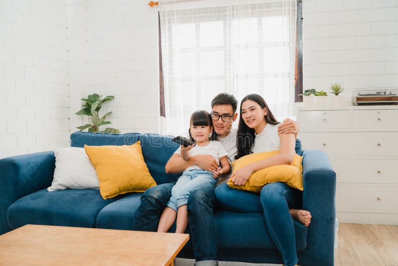 Happy Asian family enjoy their free time relax together at home. Lifestyle Korean dad, mom and daughter watching TV together and