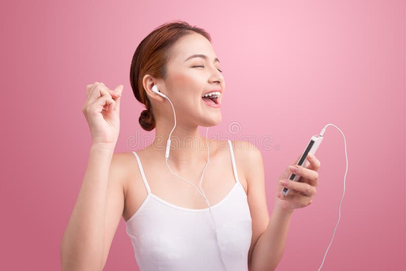 Happy asian girl dancing and listening to the music isolated on