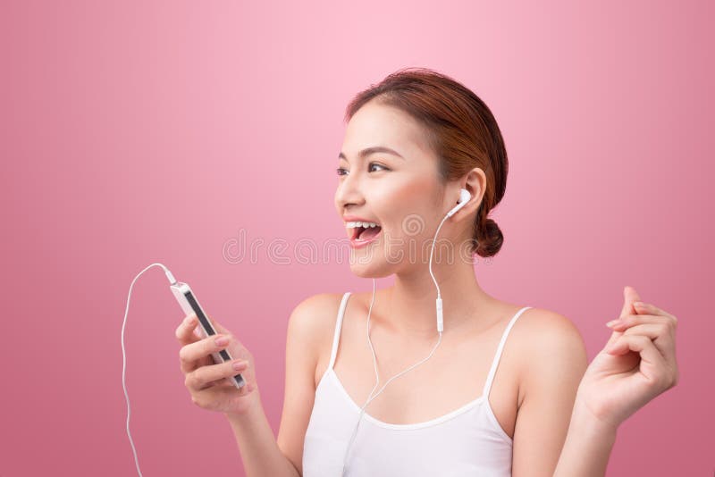 Happy asian girl dancing and listening to the music isolated on