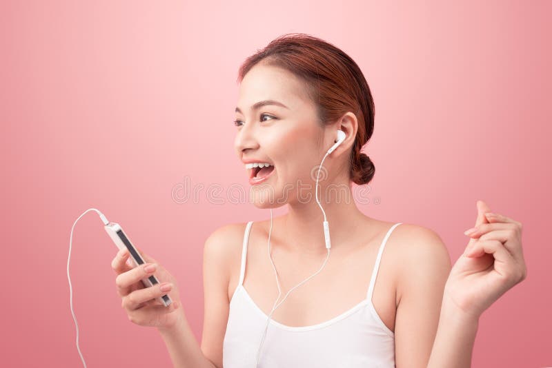 Happy asian girl dancing and listening to the music isolated on