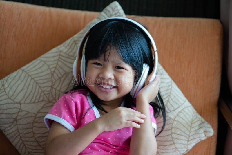 Happy Asian Girl Smiling and Enjoys Listens To Music in Headphones on ...