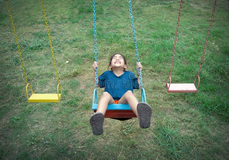 Happy asian kid play swing outdoor playpark