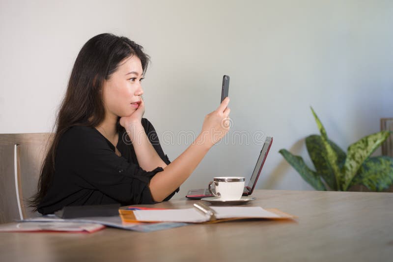 Happy Asian Korean businesswoman taking selfie photo with mobile phone at corporate company office desk smiling playful in female stock photo Happy Asian Korean businesswoman taking selfie photo with mobile phone at corporate company office desk smiling playful in female stock photo