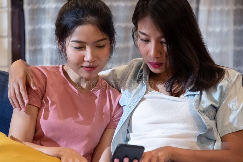 Happy Asian Lesbian Watching Video On Tablet At Sofa In