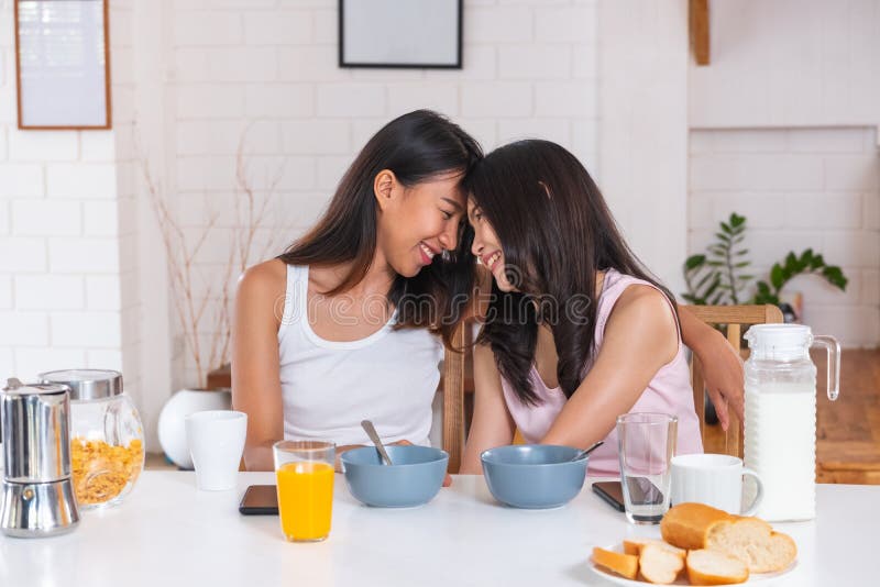 Happy Lesbian Couple Wake Up On Bed In Bedroom In Morning And Hug Each