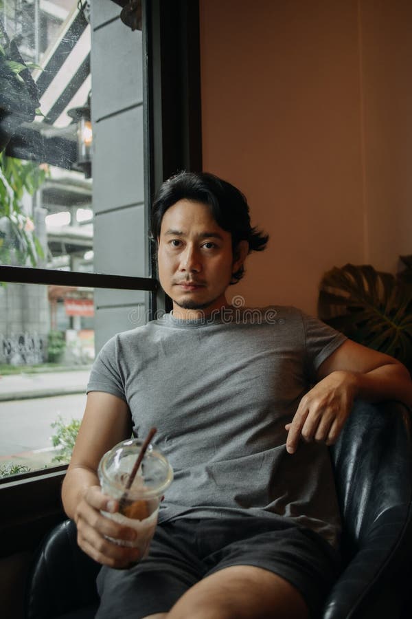 Happy man relaxed in the cafe, drinking iced coffee. stock images
