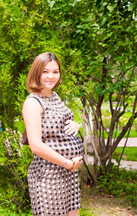 Happy asian pregnant woman with big belly rest on nature royalty free stock photo Happy asian pregnant woman with big belly rest on nature royalty free stock photo