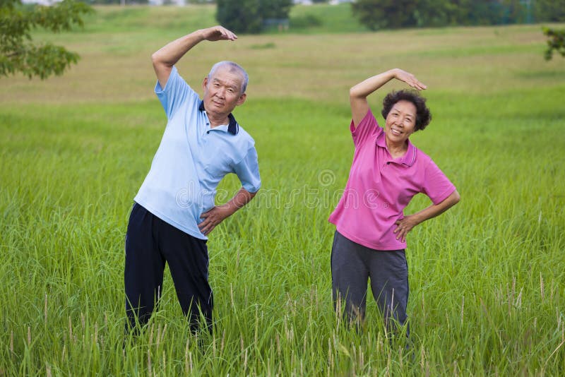 Happy asian Senior couple doing gymnastics in the park.healthy c