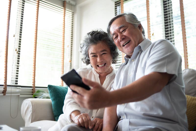 Happy Asian senior Couple using smartphone