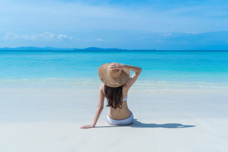 Happy Asian woman, a sexy Thai lady, relaxing and enjoying at turquoise sea near Phuket beach in summer during travel holidays