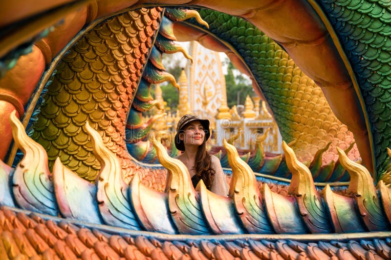 Happy asian woman smiling in colorful serpent statue at Wat Phra That Nong Bua temple stock photo