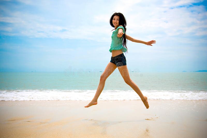 Happy asian woman walking in the air at the beach