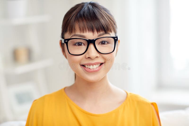 Happy asian young woman in glasses at home