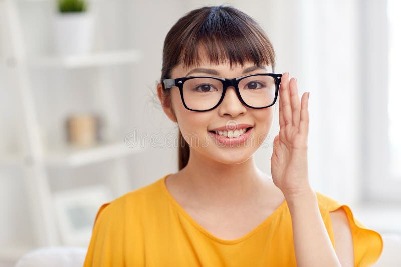 Happy asian young woman in glasses at home