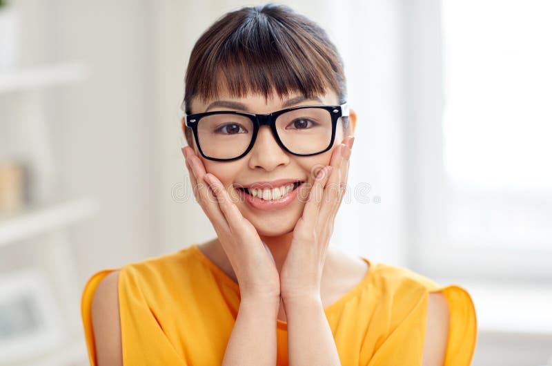 Happy asian young woman in glasses at home