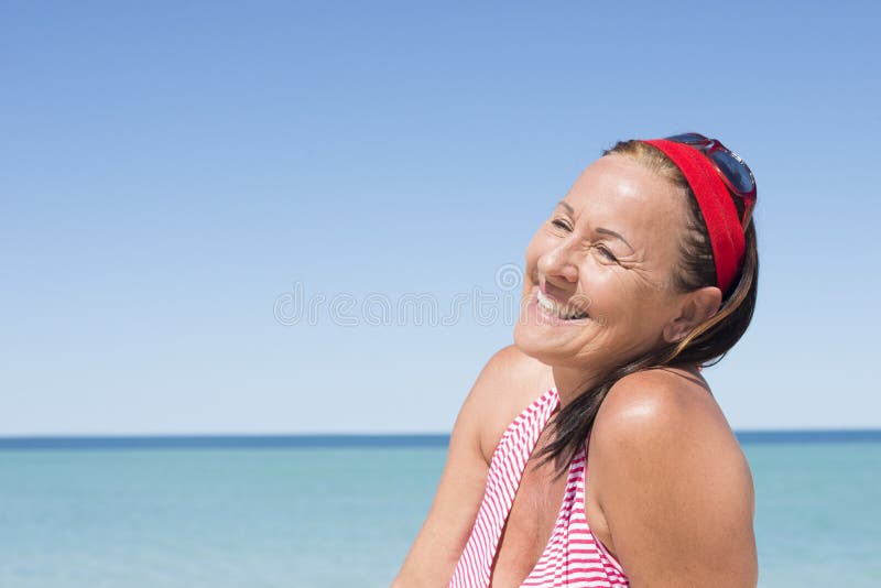 Happy attractive mature woman ocean holiday