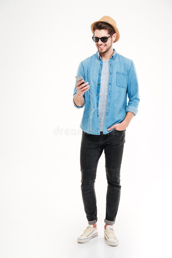Happy attractive young man listening to music from smartphone