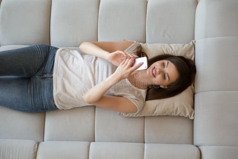 Happy Attractive Young Woman Using Smartphone Lying On Sofa Stock 