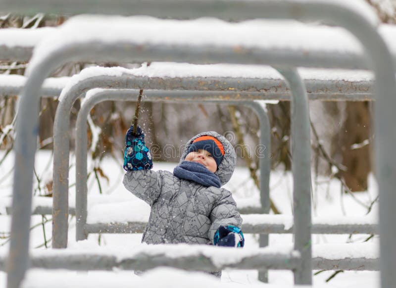 Happy Baby Boy Playing in Winter with Snow, Knocks Snow Down Stock