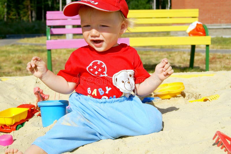 The happy baby in a sandbox