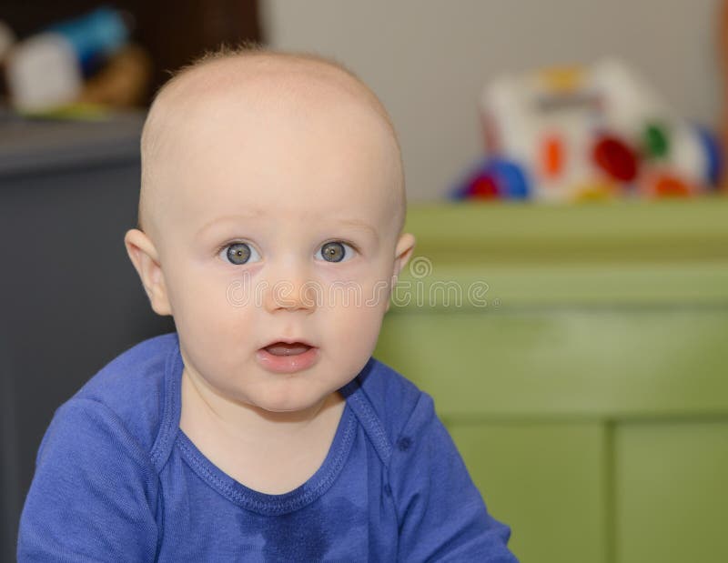 A Happy Baby Teething and Drooling with toys in the background