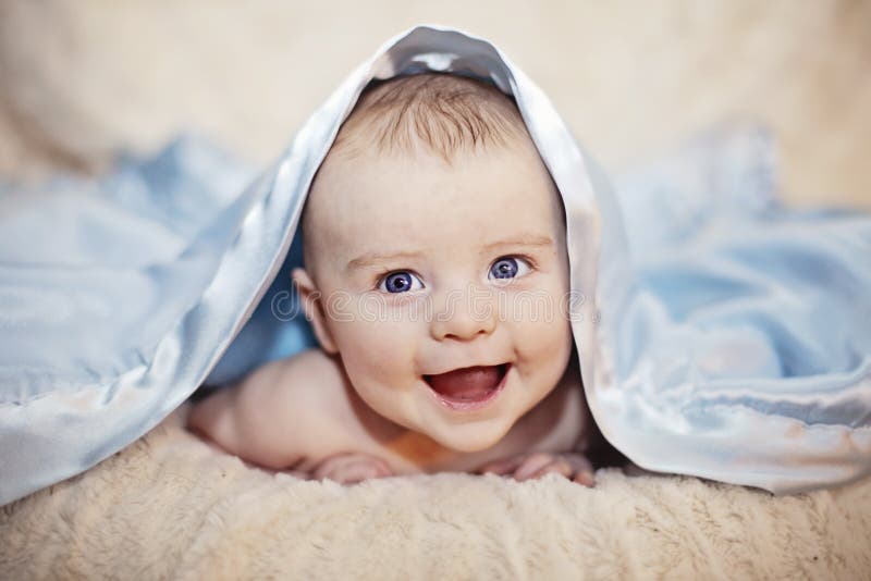 Sorridente bambino sotto coperta.