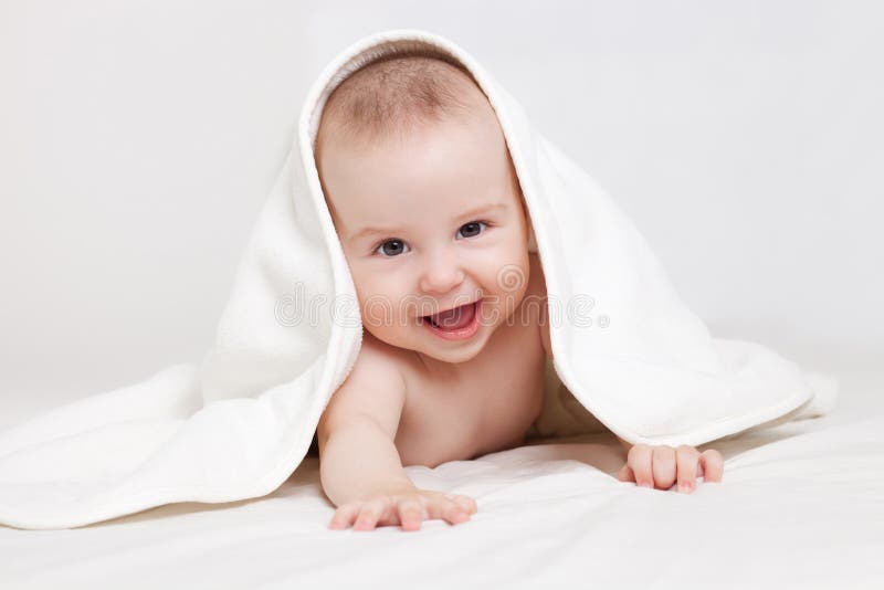 Happy baby under white blanket