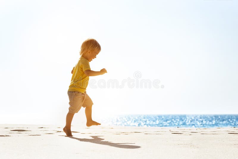Happy baby walking at lonely beach stock photography Happy baby walking at lonely beach stock photography