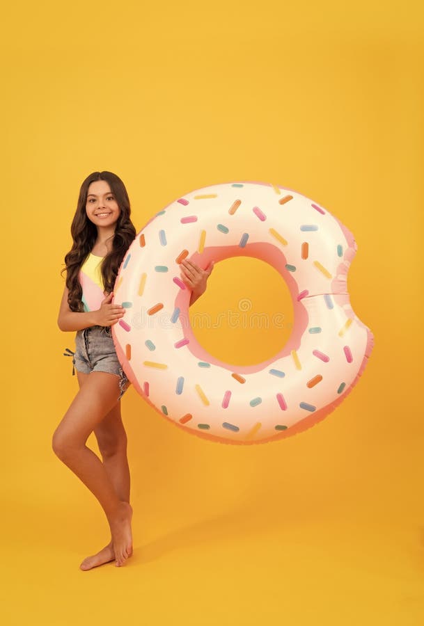 happy beach teen girl with donut inflatable ring for pool party fun on summer vacation, summertime.