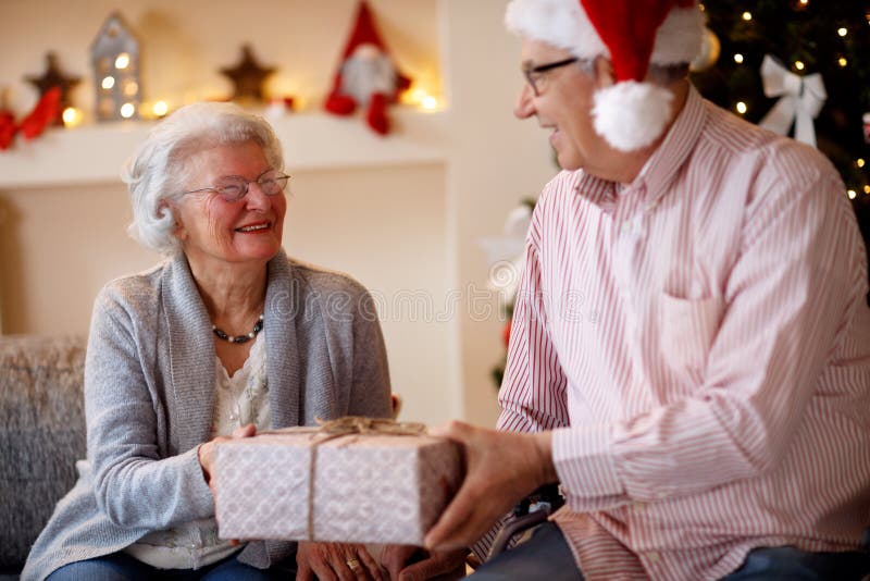 Beautiful elderly couple celebrating Christmas at home with pres royalty free stock photos Beautiful elderly couple celebrating Christmas at home with pres royalty free stock photos