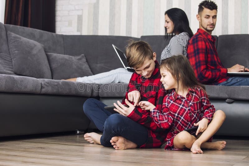 Happy beautiful family home with laptops and tablets sit in the stock photos Happy beautiful family home with laptops and tablets sit in the stock photos