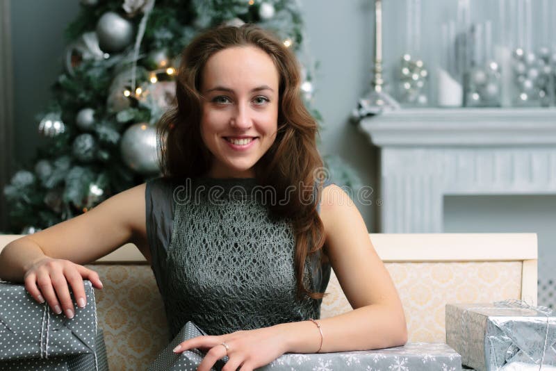 Happy beautiful girl with heap of christmas gifts sitting on sofa near christmas tree royalty free stock photo Happy beautiful girl with heap of christmas gifts sitting on sofa near christmas tree royalty free stock photo
