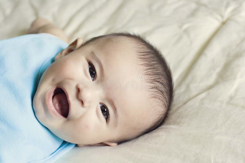 Happy beautiful hispanic baby boy laughing.