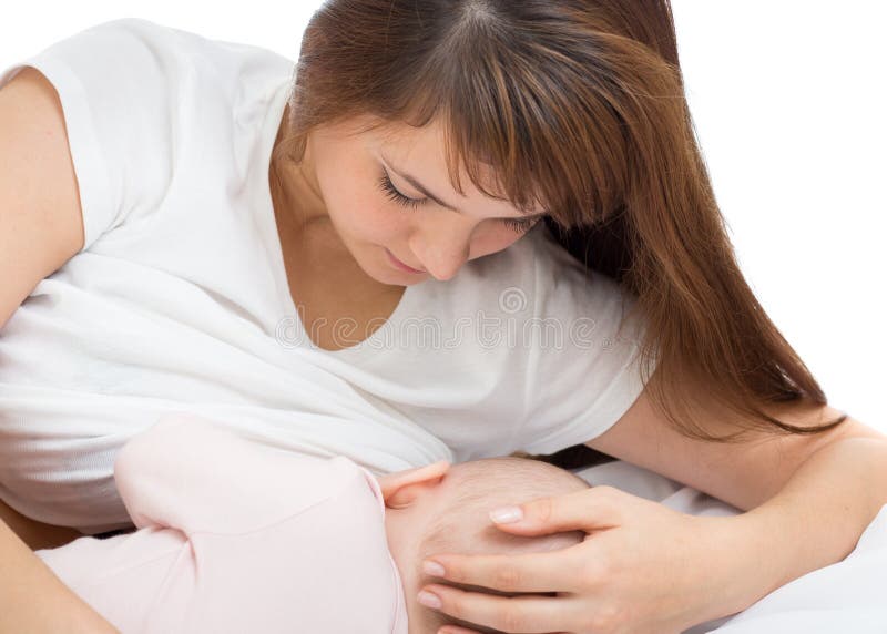 Happy beautiful mother with her baby in bed at home