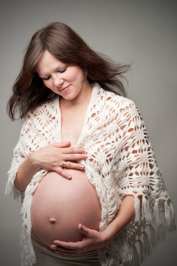 Happy beautiful pregnant woman caressing her belly