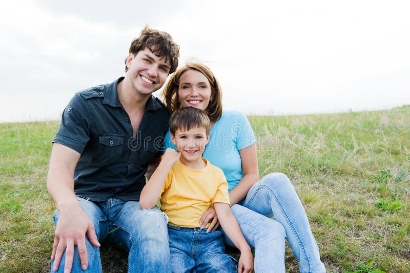 Happy beautiful young family posing outdoors royalty free stock photography