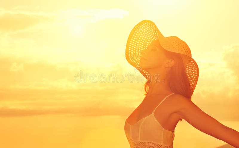 Happy beauty woman in hat opened his hands, enjoys sunset over s