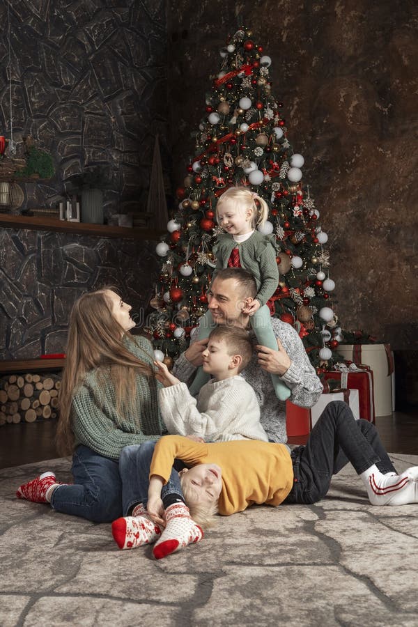 Happy big family at home. Mom dad and children near Christmas tree. Traditional xmas decorated living room. Xmas holiday